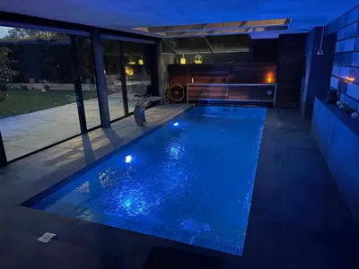 a swimming pool in the middle of a house at night at Suite with Pool Barcelona in Vilassar de Dalt