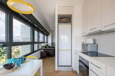 a kitchen with a white counter top and some windows at Homenfun Barcelona Fira Gran Via in Hospitalet de Llobregat