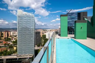 a swimming pool on the roof of a building at Homenfun Barcelona Fira Gran Via in Hospitalet de Llobregat