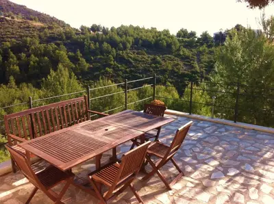 a wooden table and chairs on a patio at Indep suite 2 rooms in private villa views in Castelldefels