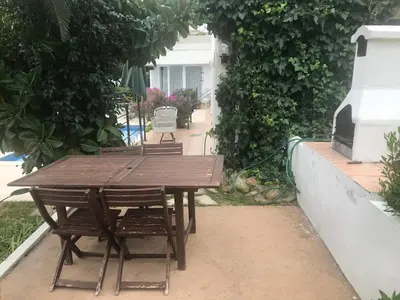 a wooden table and chairs on a patio at Indep suite 2 rooms in private villa views in Castelldefels