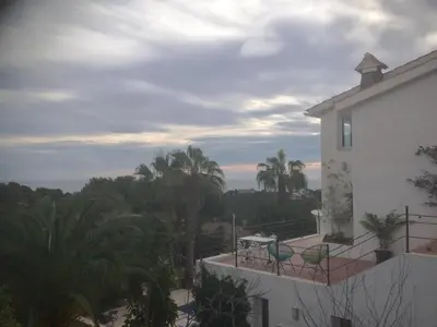 a balcony of a white building with palm trees at Indep suite 2 rooms in private villa views in Castelldefels