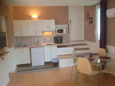 a kitchen with white cabinets and a table and chairs at Indep suite 2 rooms in private villa views in Castelldefels