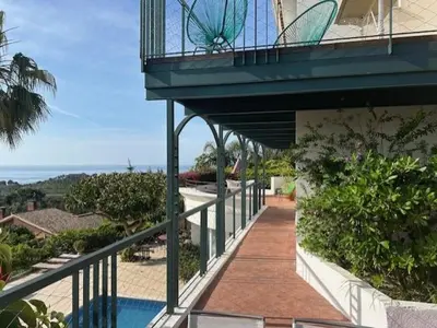 a balcony of a building with a walkway next to a pool at Independent Room in private villa with view1 in Castelldefels
