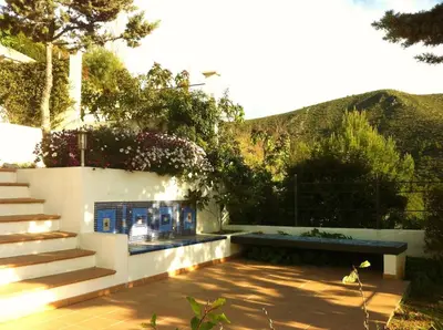 a patio with a bench and stairs with mountains in the background at Independent Room in private villa with view1 in Castelldefels