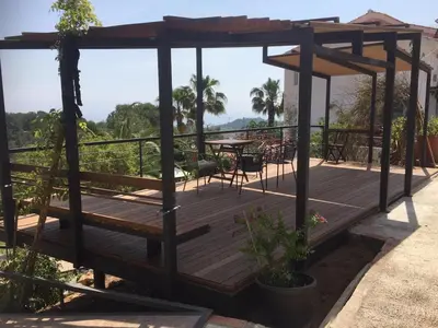 a wooden deck with a table and chairs on it at Independent Room in private villa with view1 in Castelldefels