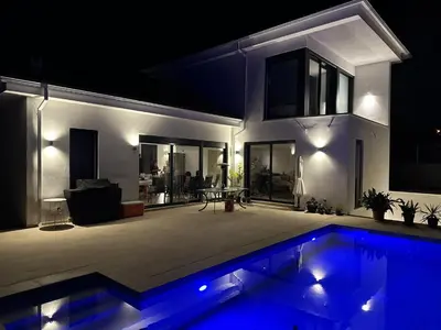 a house with a swimming pool at night at Luxury sea view apartment near Sitges in Olivella