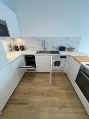 a kitchen with a sink and a washing machine at Luxury sea view apartment near Sitges in Olivella