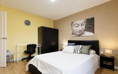 a bedroom with a white bed and a large painting on the wall at Fantastic Penthouse in Barcelona