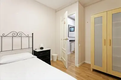 a white bedroom with a bed and an open door at Fantastic Penthouse in Barcelona