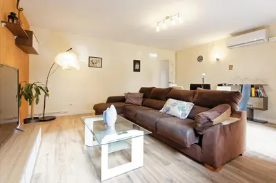 a living room with a brown couch and a table at Fantastic Penthouse in Barcelona