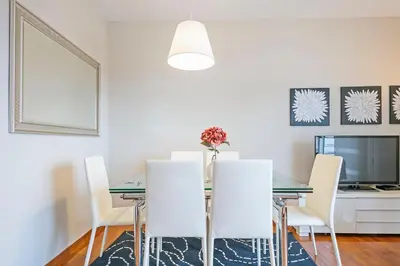 a dining room with a table and white chairs at Sarria Attic in Barcelona