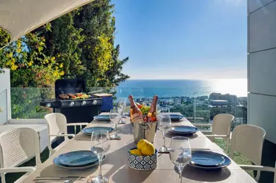 a table with wine glasses and a view of the ocean at Villa in Sitges with Pool, Jacuzzi, BBQ, View, AC, 12Pax in Sitges