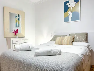 a bedroom with two beds with white sheets at Apartment Iolanda in Vilanova i la Geltrú