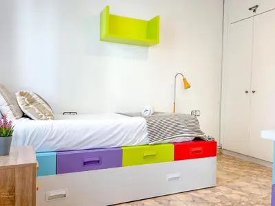 a bedroom with a bed with colorful drawers at Apartment Iolanda in Vilanova i la Geltrú