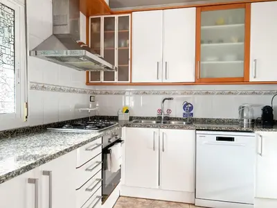 a kitchen with white cabinets and a sink at Apartment Iolanda in Vilanova i la Geltrú