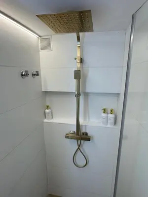 a shower in a bathroom with white walls at SuitePoolBarcelona in Vilassar de Dalt