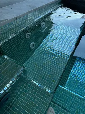 a swimming pool with green tiles in the water at SuitePoolBarcelona in Vilassar de Dalt
