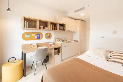 a bedroom with a bed and a desk and a table at Canvas Sabadell Llac in Sabadell