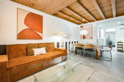a living room with a couch and a dining room at Encantador Apartamento con Terraza en Sants in Barcelona