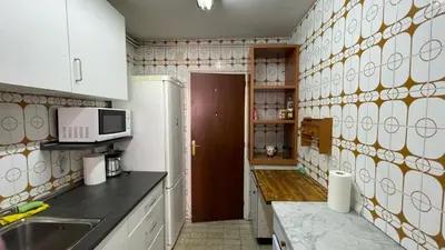 a kitchen with white cabinets and a microwave at Maresme in Canet de Mar