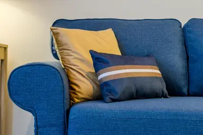 a blue couch with two pillows on it at Novus Homes Barcelona Plaza España in Barcelona