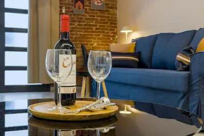 a bottle of wine and two wine glasses on a table at Novus Homes Barcelona Plaza España in Barcelona