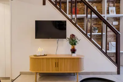 a living room with a tv and a table with candles at Novus Homes Barcelona Plaza España in Barcelona