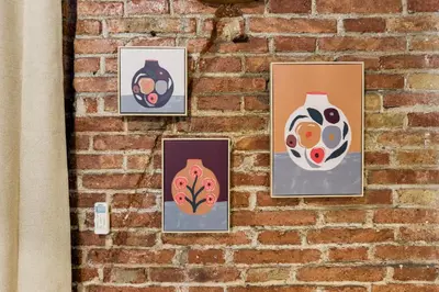 a group of paintings on a brick wall at Novus Homes Barcelona Plaza España in Barcelona