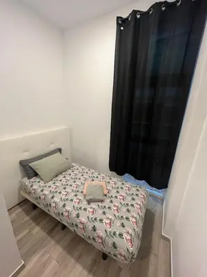 a small bedroom with a bed with a curtain at 3 min to metro Center 15 min by metro Beach 15min in Santa Coloma de Gramanet