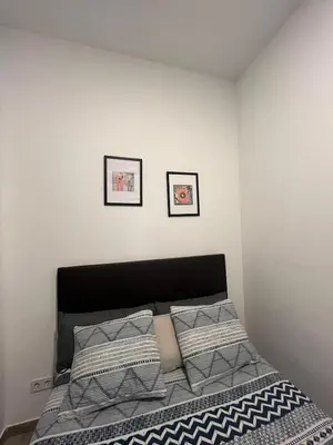 a bedroom with a bed with two pictures on the wall at 3 min to metro Center 15 min by metro Beach 15min in Santa Coloma de Gramanet