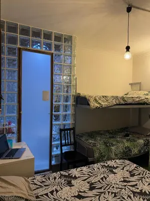 a bedroom with two beds and a desk with a laptop at stressless house in Barcelona