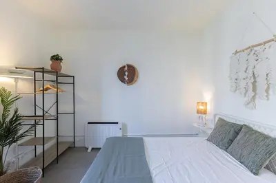 a white bedroom with a bed and a shelf at ATA Five Rooms Mid term Rental in Barcelona