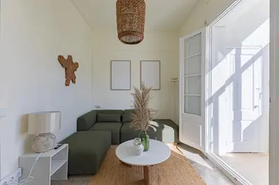 a living room with a green couch and a table at ATA Five Rooms Mid term Rental in Barcelona