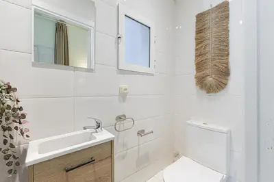 a white bathroom with a sink and a toilet at ATA Five Rooms Mid term Rental in Barcelona