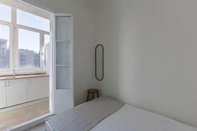a white room with a bed and a window at ATA Five Rooms Mid term Rental in Barcelona