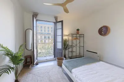 a bedroom with a bed and a large window at ATA Five Rooms Mid term Rental in Barcelona
