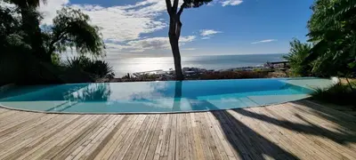 a swimming pool with a view of the ocean at Casa Roca Lujo mediterráneo con piscina infinity in Sitges