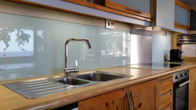a kitchen with a stainless steel sink and wooden counters at Casa Roca Lujo mediterráneo con piscina infinity in Sitges