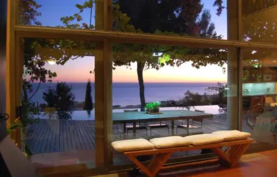 a glass window with a table and a view of the ocean at Casa Roca Lujo mediterráneo con piscina infinity in Sitges