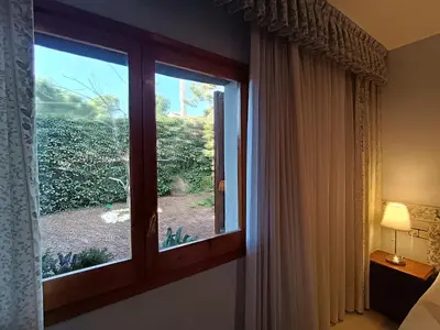 a window in a bedroom with a view of a garden at El Mirador de Can Barri BB Vistas Piscina y Desayuno Gourmet in Bigues i Riells