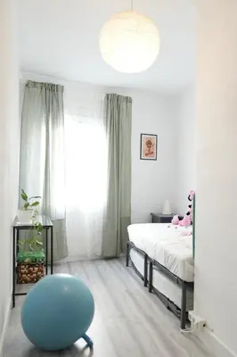 a bedroom with a bed and a blue chair at \u6ee8\u6d77\u522b\u5885 in Premia de Dalt