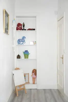 a room with white shelves with a doll and a chair at \u6ee8\u6d77\u522b\u5885 in Premia de Dalt