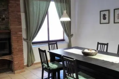a dining room with a table and chairs and a window at Casa de pueblo con encanto in Arbós