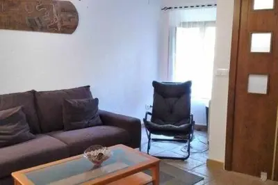 a living room with a couch and a chair at Casa de pueblo con encanto in Arbós
