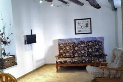 a living room with a couch and a tv at Casa de pueblo con encanto in Arbós