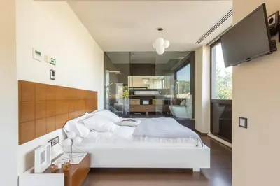 a bedroom with a white bed and a large window at Espai Oliveres Barcelona Villa con piscina in Papiol