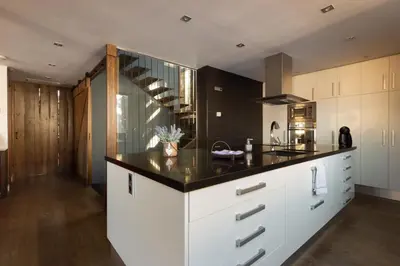 a kitchen with white cabinets and a black counter top at Espai Oliveres Barcelona Villa con piscina in Papiol