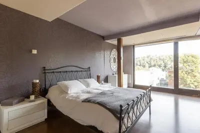 a bedroom with a large bed and a large window at Espai Oliveres Barcelona Villa con piscina in Papiol