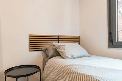 a small bedroom with a bed and a table at Apartamento reformado de 3 habitaciones en Sagrada Familia in Barcelona